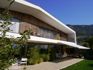 a building with a balcony with chairs and tables at House Plan 'C' in Maishofen