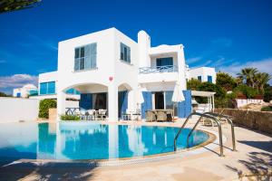 a white house with a swimming pool in front of it at Luxury holiday villa Apollo 9 in Paphos