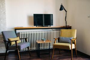 a living room with three chairs and a tv at NS center apartment in Novi Sad