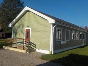 un pequeño edificio verde con una rampa delante de él en Hagfors Hostel, en Råda