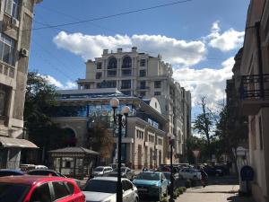 a city street with cars parked in front of a tall building at Адмирал хостел in Odesa