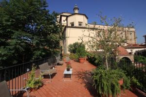 a patio with chairs and a building in the background at Studios Garden Terrace Oltrarno in Florence