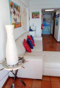 un soggiorno con divano bianco e un vaso sul tavolo di Casa do Espadarte a Sesimbra