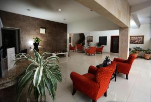 a lobby with red chairs and a plant in the middle at Hotel Marel in Poza Rica de Hidalgo