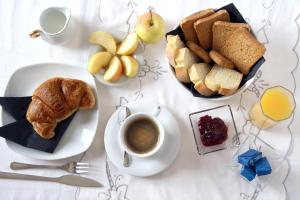 a table with a breakfast of coffee and bread and fruit at B&B A Casa Romar in Turin +31 photos