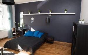 1 dormitorio con 1 cama con almohadas azules en EASY RENT Apartments - Konopnicka 11, en Lublin