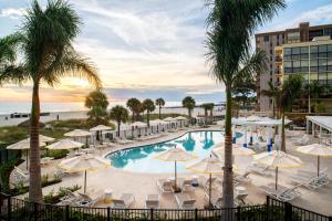 圣徒皮特海滩Sirata Beach Resort St Pete Beach的一张带遮阳伞和海滩的游泳池的图片