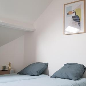 ダンケルクにあるl’appart Malouin à 50M de la plageのベッドルーム1室(ベッド1台付)が備わります。壁に鴨の写真が飾られています。
