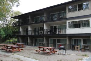 eine Gruppe Picknicktische vor einem Gebäude in der Unterkunft Okanagan Royal Park Inn by Elevate Rooms in Vernon