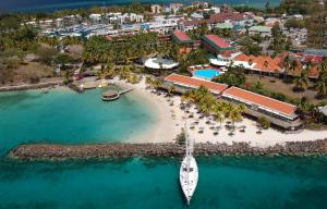 eine Luftansicht eines Resorts mit einem Boot am Strand in der Unterkunft Hotel Bakoua Martinique in Les Trois-Îlets