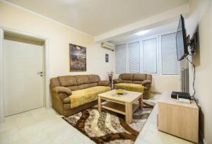 - un salon avec un canapé et une table dans l'établissement Apartman Centar 1, à Podgorica