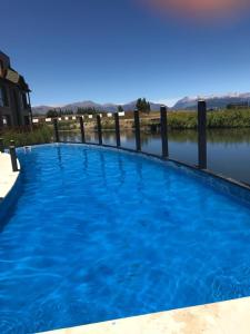 a large blue swimming pool next to a body of water at Departamento Cipres Villa Huapi Bariloche in San Carlos de Bariloche