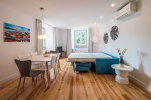 uma sala de estar com uma mesa de jantar e cadeiras em Sunshine House - Exclusive Apartment - Home By The Castle em Lisboa