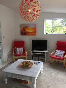 a living room with a table and two chairs and a tv at Studio 531 in Coromandel Town