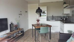 a living room with a table and a kitchen at Osborg State in Buren