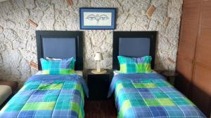 1 dormitorio con 2 camas y pared de piedra en Habitación amplia cerca de Andares, en Guadalajara