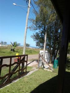 a wooden fence with a gate in a field at Casa Fávero Bairro Arco iris in Capão da Canoa