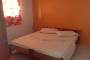 1 cama con 2 almohadas en una habitación en Pousada do Mar en Río Grande