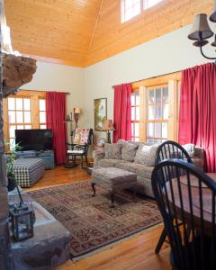 a living room with a couch and red curtains at Wayward Cottage in Pisgah