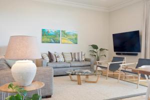 a living room with a couch and a tv at Villa Maria Barossa Luxury Guesthouse in Tanunda