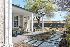 un patio con una mesa y algunas plantas en Villa Maria Barossa Luxury Guesthouse, en Tanunda