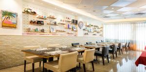 a dining room with a long table and chairs at Shichi Hotel in Kaohsiung