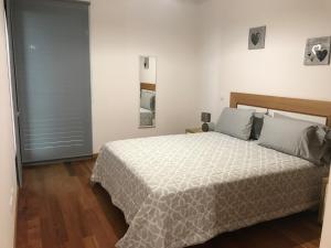 a bedroom with a bed with a white comforter at Lou-Jos in Funchal +39 photos