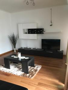a living room with a black coffee table and a flat screen tv at Lou-Jos in Funchal