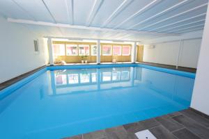 a large swimming pool with blue water at Hotel Gudhjem in Gudhjem