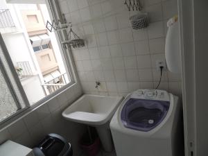La petite salle de bains est pourvue de toilettes et d'un lavabo. dans l'établissement Apartamento Confortavel em Balneário Camboriu, à Balneário Camboriú