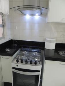 a kitchen with a stove top oven in a kitchen at Apartamento Confortavel em Balneário Camboriu in Balneário Camboriú