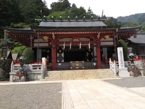 a shrine with a building in the middle of a street at Togakubo in Isehara