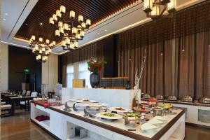 a buffet line with plates of food in a restaurant at 西安汉乐府酒店 - Xi'an Paradise Hotel of Han Dynasty in Xi'an