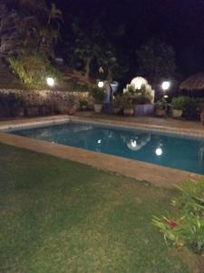 a swimming pool in a yard at night at Suites em meio a Mata Atlântica in Itaipava