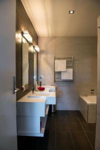 a bathroom with two sinks and a tub at Luxurious Loft Apartments in the heart of Ahuriri in Napier