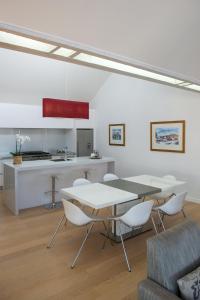 a living room with a table and chairs and a kitchen at Luxurious Loft Apartments in the heart of Ahuriri in Napier