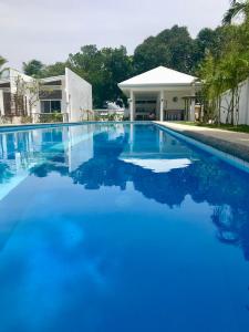 einen Pool mit blauem Wasser vor einem Haus in der Unterkunft 1949 Dreamy Home in Panglao