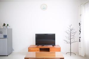 a living room with a tv on a wooden table at 1949 Dreamy Home in Panglao Island
