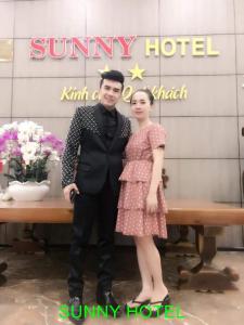 a man and a woman standing next to a table at Sunny Hotel in Phan Rang–Tháp Chàm