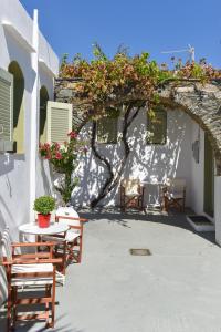 a patio with two chairs and a table and a building at Giannakas Studios in Platis Gialos