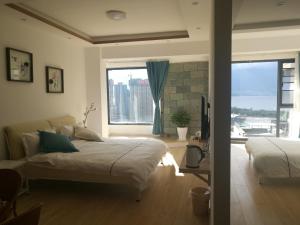 a bedroom with two beds and a large window at Home Bird Garden Villa in Dali
