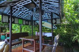 a table and a surfboard under a pergola at Villa Elita in Sudipen