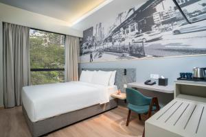a bedroom with a bed and a painting on the wall at Travelodge Bukit Bintang in Kuala Lumpur