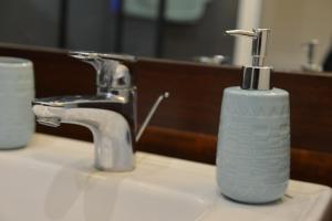 a soap dispenser sitting on top of a bathroom sink at studio "BLEU TURQUOISE" in Le Gosier +34 photos