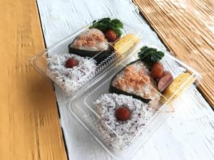three plastic containers of sushi and rice on a table at Yenn's Marina Inn Zamami Condominium in Zamami