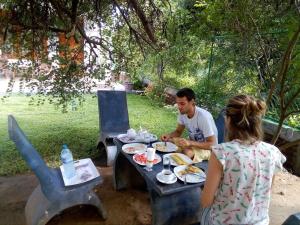 a man and a woman sitting at a table with food at River Nature Park in Polonnaruwa