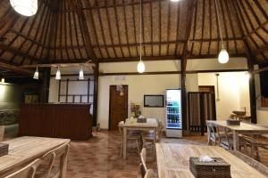 a large room with tables and chairs and lights at Daphila Cottage in Nusa Penida