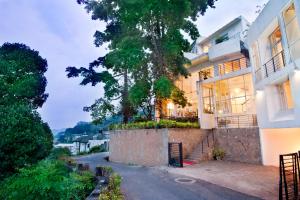 una casa con un albero sul lato di una strada di Hotel See Kandy a Kandy