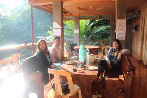 um grupo de pessoas sentadas numa mesa num restaurante em Batad Transient House em Banaue