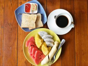 a table with two plates of food and a cup of coffee at Baan Jaidee Guesthouse in Trat